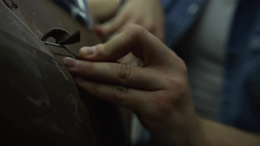 A person with a tool shaving chocolate