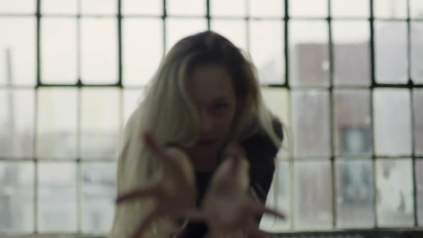 A woman is dancing and waving her arms forward