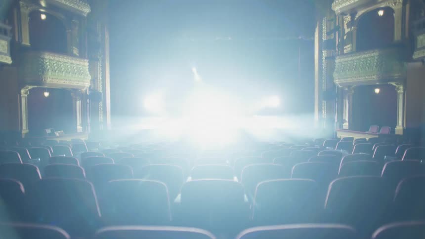 The lights shine on stage in the empty theater
