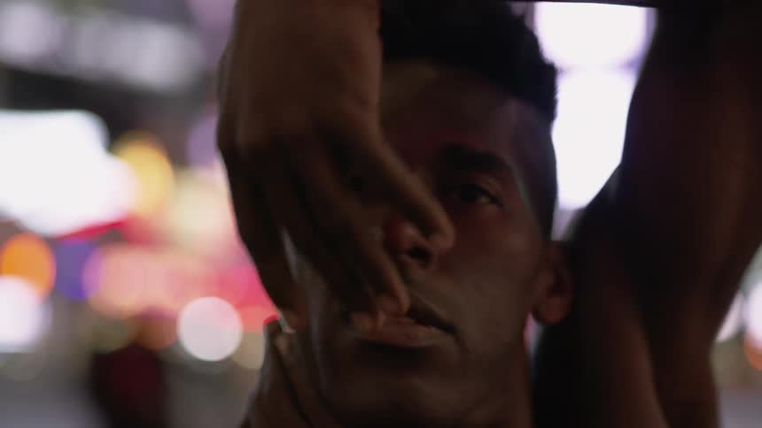 A man dancing with city lights in the background