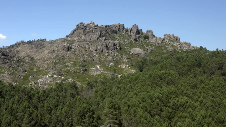A view of a mountain with rocks and trees on it