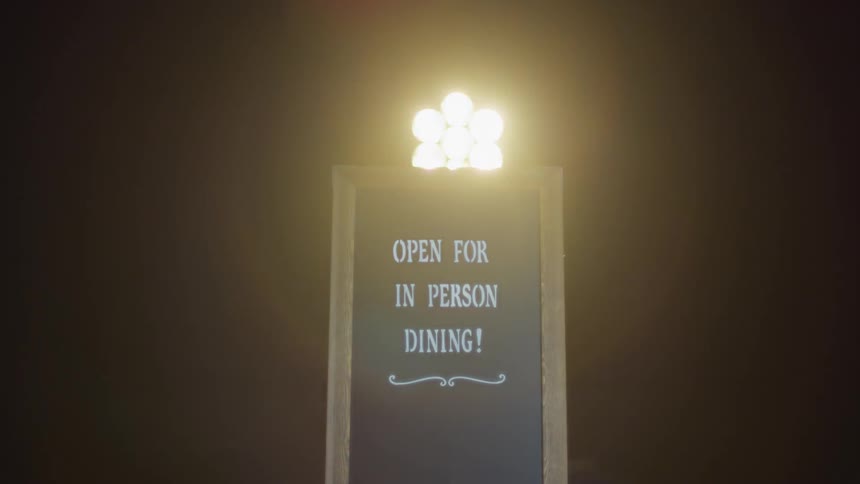 A sign with spotlights and a black background