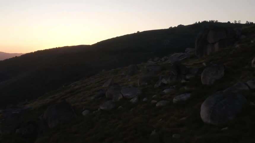 Aerial view of rocky mountains being silhuetted against the sunset