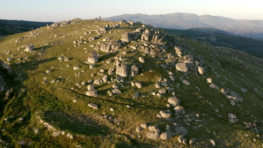 A road runs around a mountain that is covered in rocks and boulders