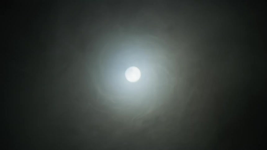 A light grows brighter at the end of a smoke filled tunnel