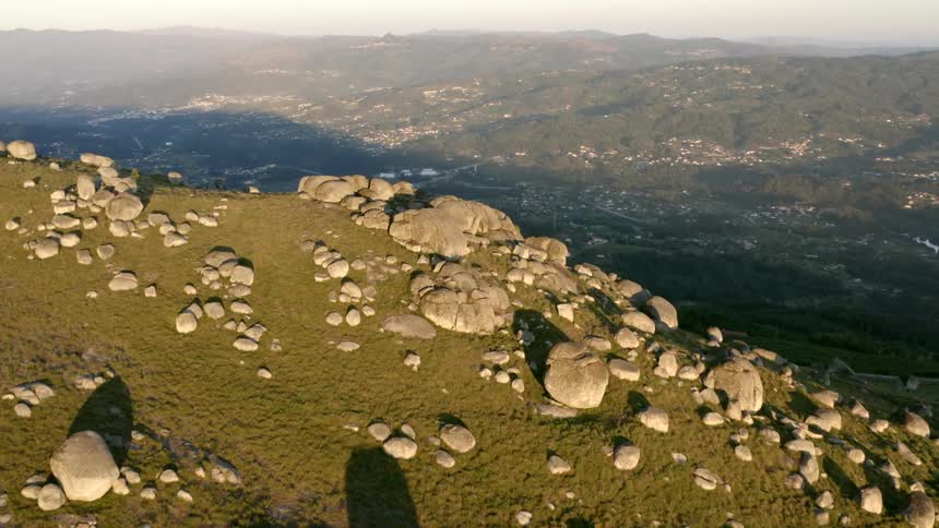 A rock covered hill looms over a spread out neighborhood