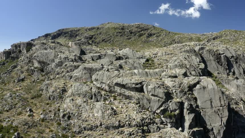 Aerial view of rocky mountain against blue sky