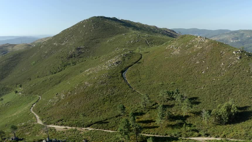 Narrow country roads run wind along the side and to the top of rolling hills