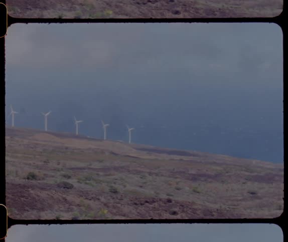 Distant wind turbines running on the coast overlooking sea