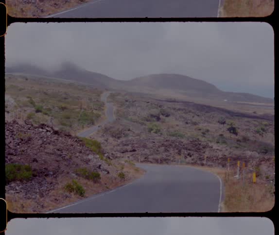 A vintage filmstrip of a road in the hills