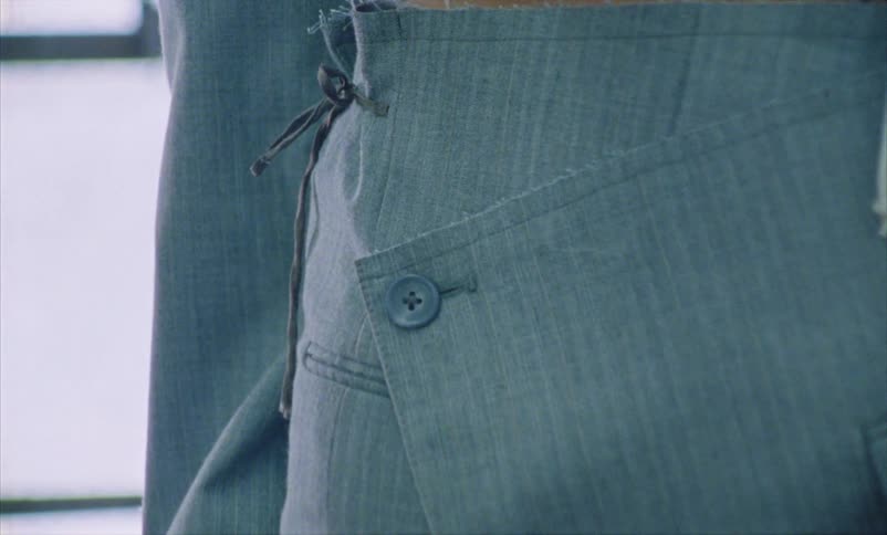 A button on a skirt worn by a young woman