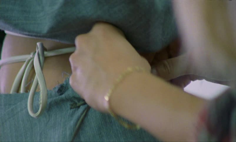A designer ties the drawstring on the side of a models pants