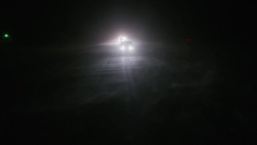 Cars driving outdoors with headlights on