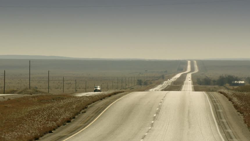 A pair of roads through a vast grassland in the evening