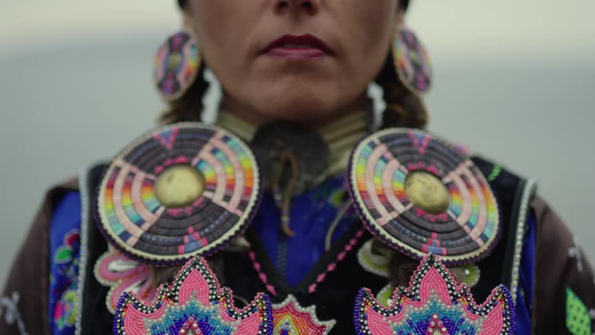 A native american woman wearing traditional beaded garb