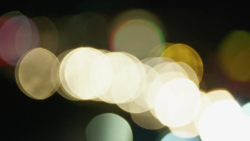 Blurred car headlights glowing in the dark