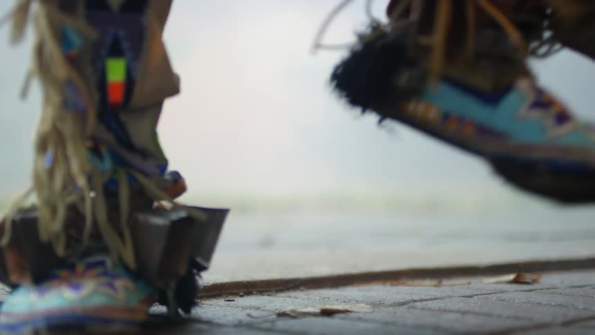 A native american powwow dancer wearing moccasins is stomping his feet