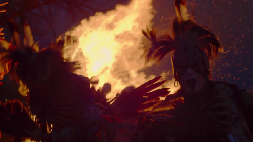 Native americans perform near a large bonfire