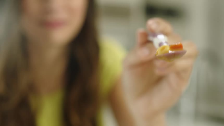 A spoonful of baby food is swayed back and forth by mom as she tries to feed baby