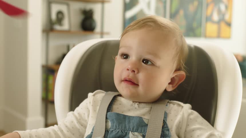 A child eating food in a chair