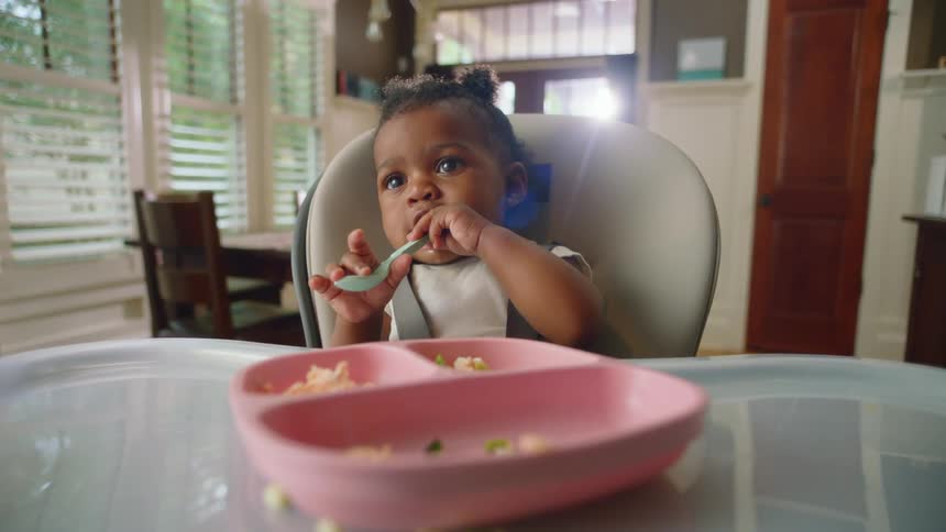 A child playing with a spoon in a house
