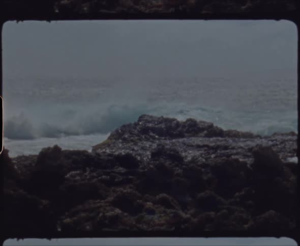 A rocky shore with waves with the ocean sky and clouds in the background