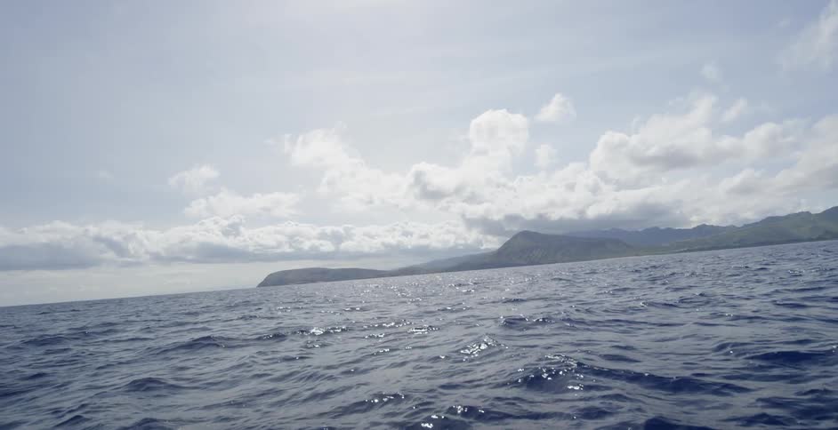 Choppy ocean waters with mountains in the background