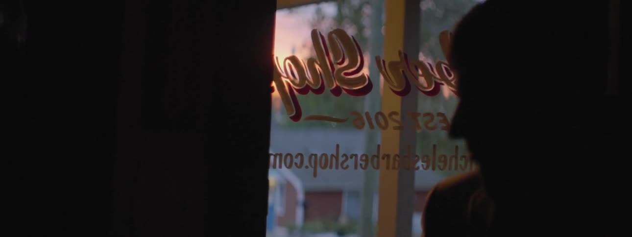 Someone enters a barber shop and turns on the light