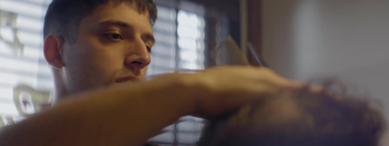 A man is styling hair in a barber shop