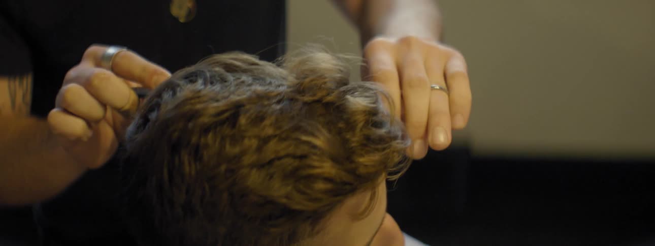 A man is getting a haircut in a barber shop