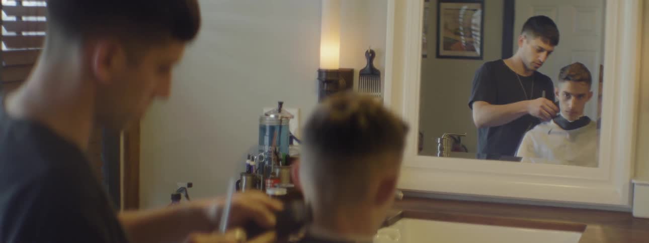 Barber trimming a patron's neck with clippers