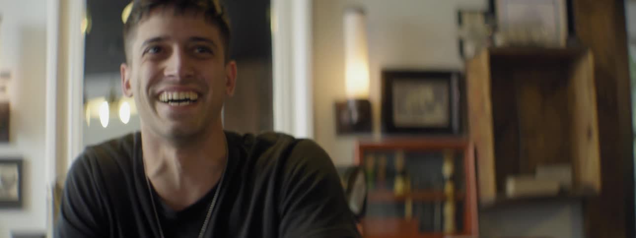 A man in a dark t-shirt laughs