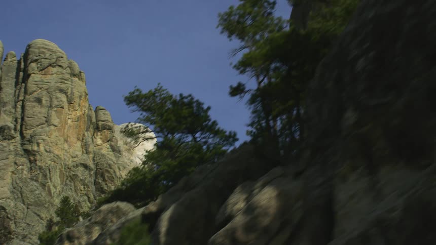The profile of george washington on mount rushmore under a blue sky