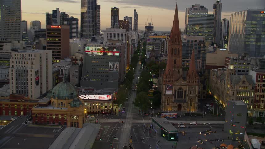 A busy city with towers high in the sky and cars traveling on the streets