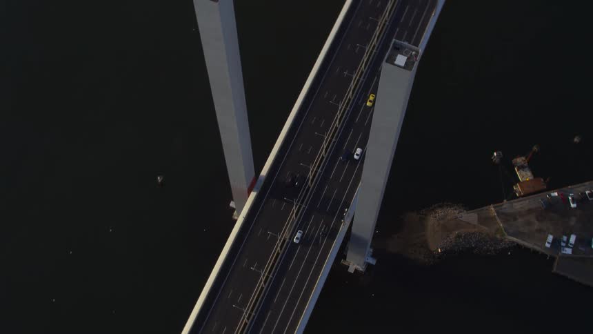 Aerial view of traffic on a bridge over a river at morning