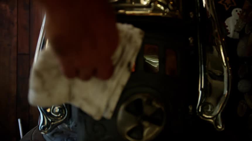 Person closes stove on wood burning stove using folded cloth