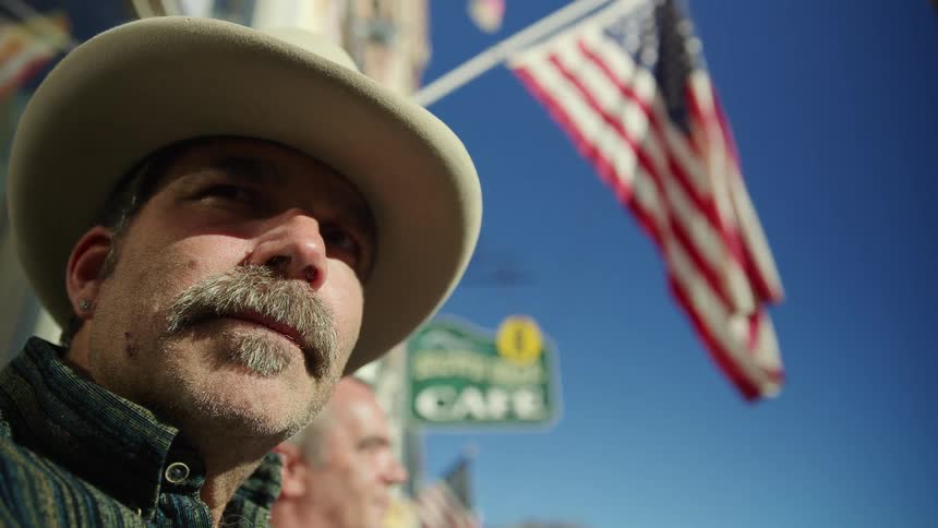 People are standing outside the cafe under the american flag
