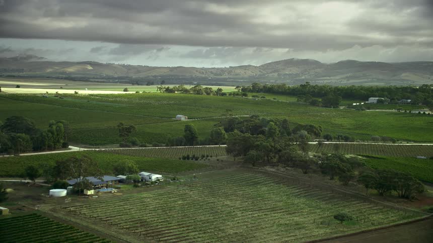 A large stormfront is moving over farmland