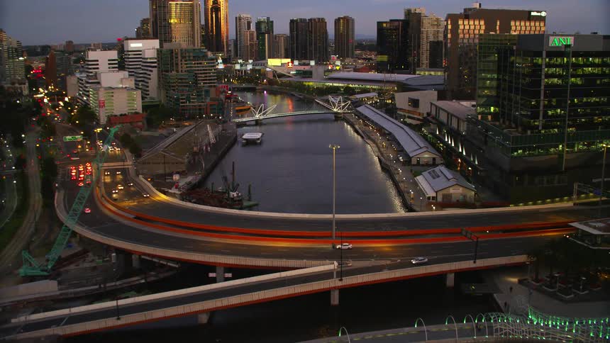A city with a river with bridges with buildings the sky and clouds in the background
