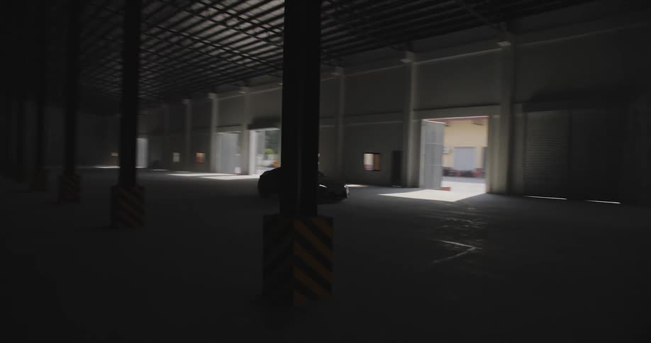 Car driving inside an empty warehouse
