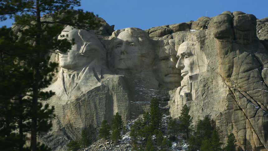 The faces of american presidents are carved into the side of a canyon