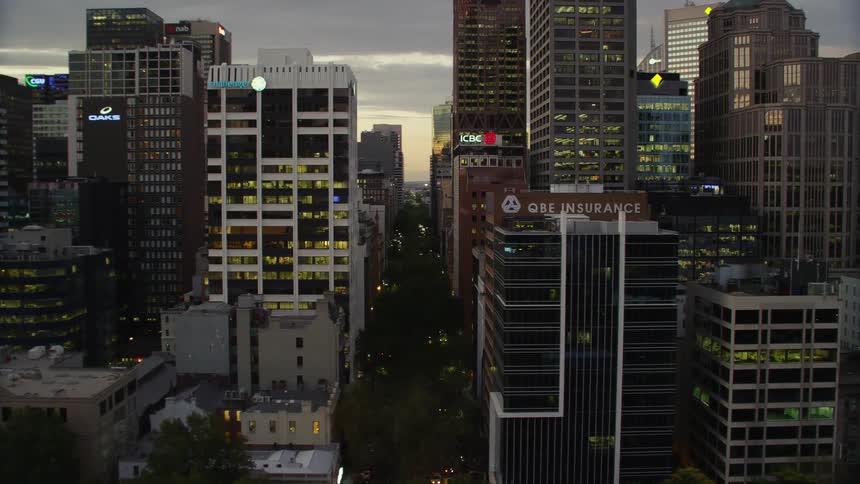 A city with buildings roads vehicles and trees with the sky and clouds in the background