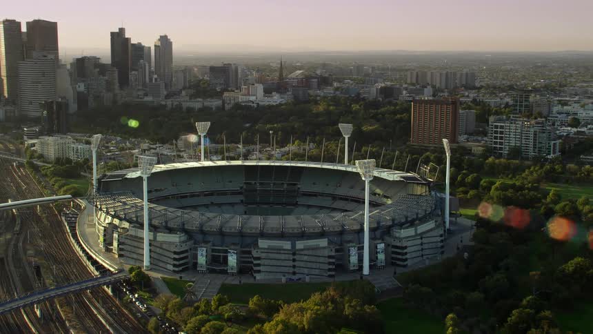 Aerial view of a stadium in front of the city skyline at sunset