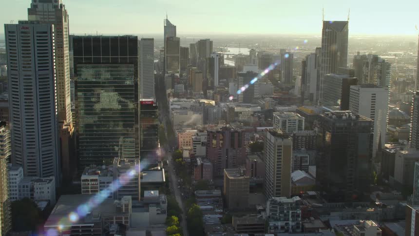 Sunlight shining over buildings and tall skyscrapers in a large city