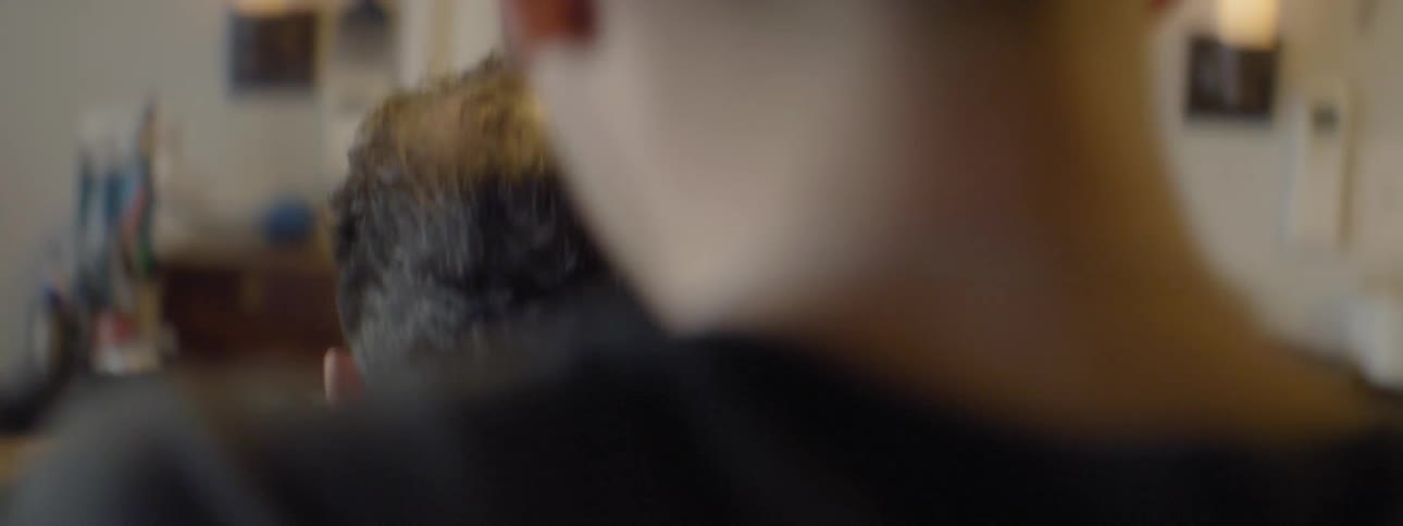 A man trims another man's hair