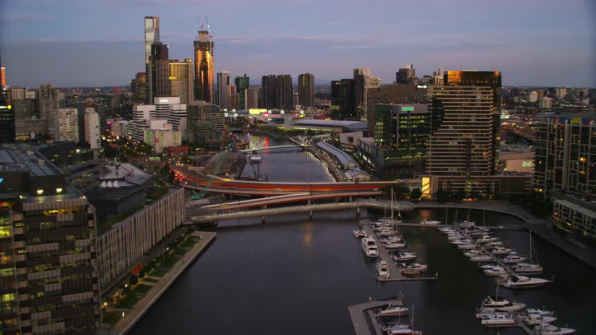 Aerial view of high rise buildings and city river with boats at harbor