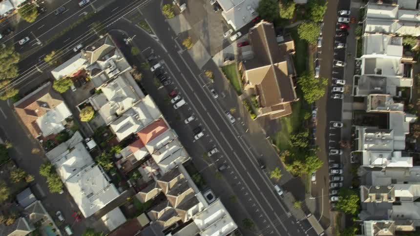 A neighborhood with houses roads vehicles and trees
