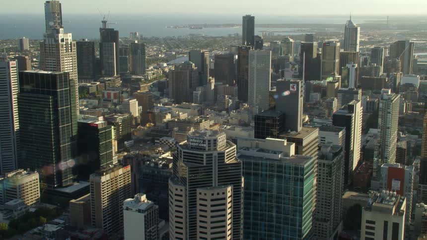 Aerial view of skyscrapers on the skyline of a coastal city at evening