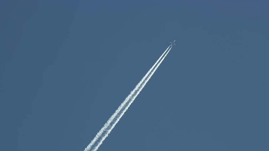 A jet leaves a trail as it flies through the sky on a clear day