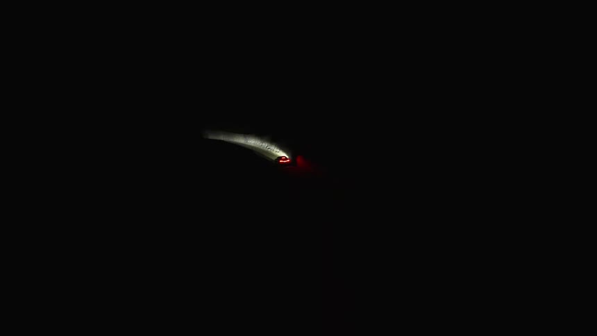 A vehicle is driving on the pitch black road